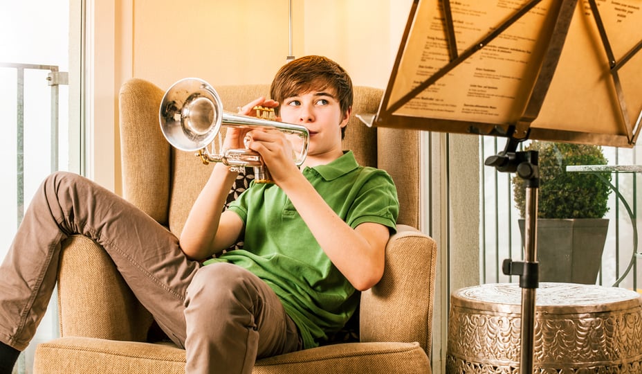 teenage male playing trompet in a living room