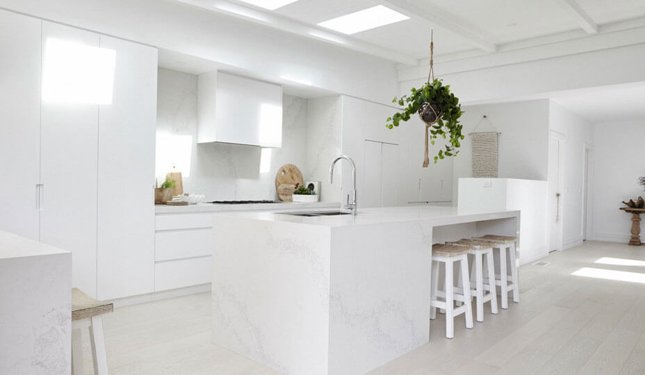 all white kitchen with a marble island