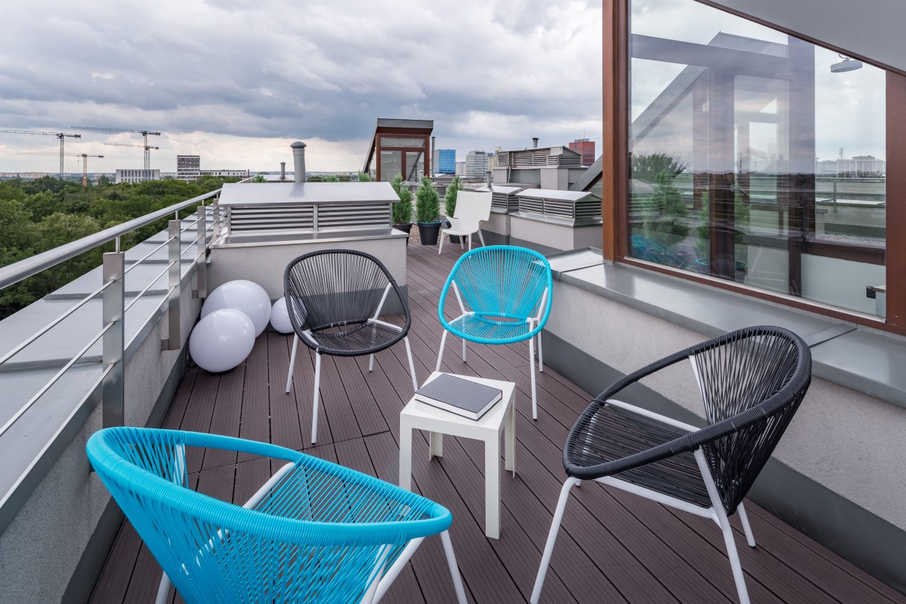 Roof terrace with retro 50s chairs in blue and black vinyl straps