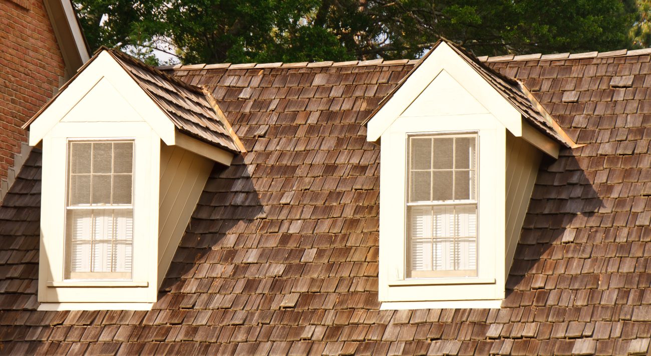 Two mansards with lattice windows and a natural cedar shingle-covered roofing