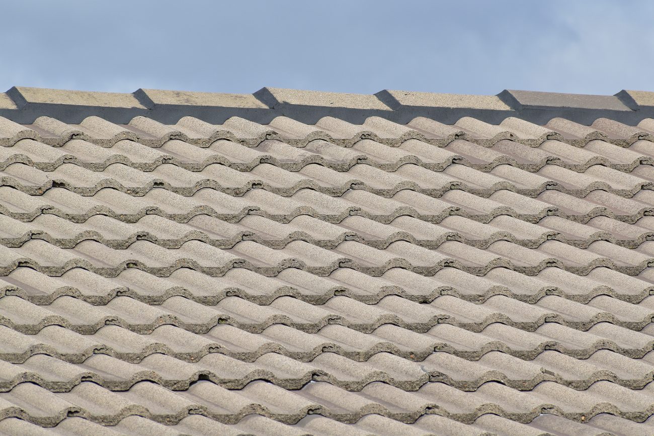 Sloping roof covered with natural-coloured corrugated concrete tiles