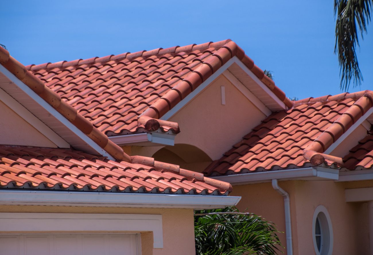 Orange clay tiles on the sloping roof of a yellow Mediterranean-style villa