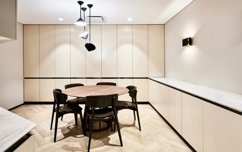 modern kitchen with cream colour cabinets and circular table with black chairs
