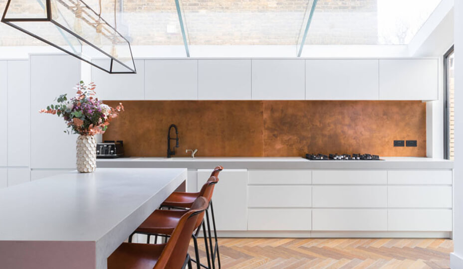 white kitchen with copper backsplash