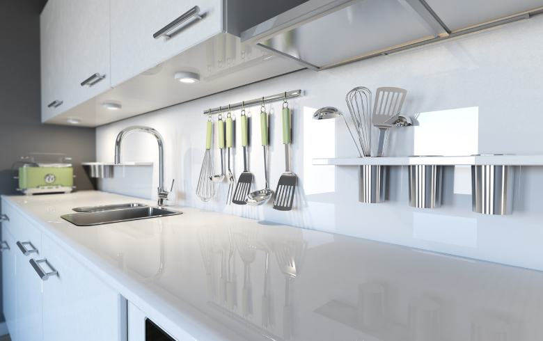 white kitchen with kitchen tools hanging on backsplash