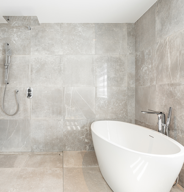 A wet room featuring a neutral colour palette, a freestanding tub, and a waterfall shower