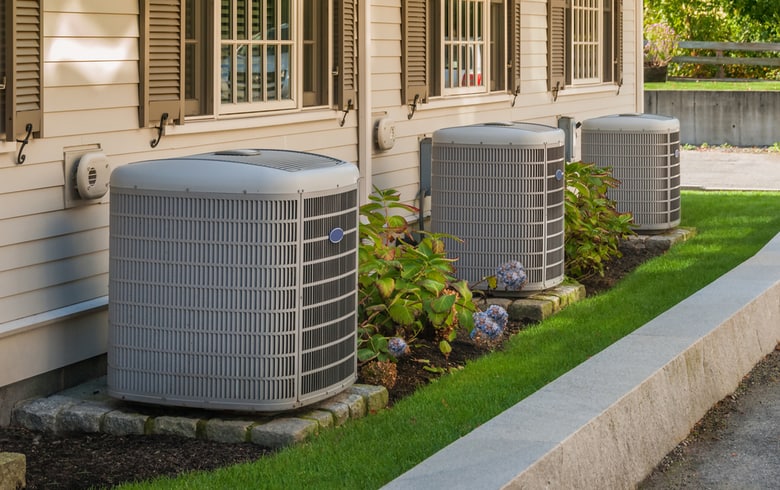 three exterior HVAC systems with landscaping