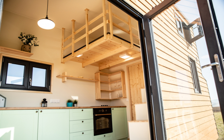 interior of cozy wooden tiny home with glass door