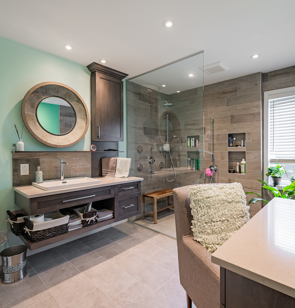 Luxurious bathroom with makeup station, walk-in shower, and floating vanity