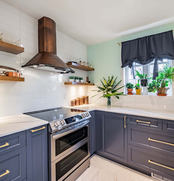Newly renovated kitchen with beautiful copper ventilation system and blue cabinets