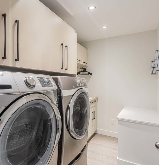 laundry room with washer, dryer, and beige cabinets