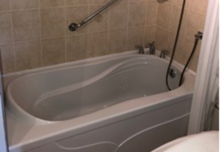 bathroom with beige backsplash and tub shower