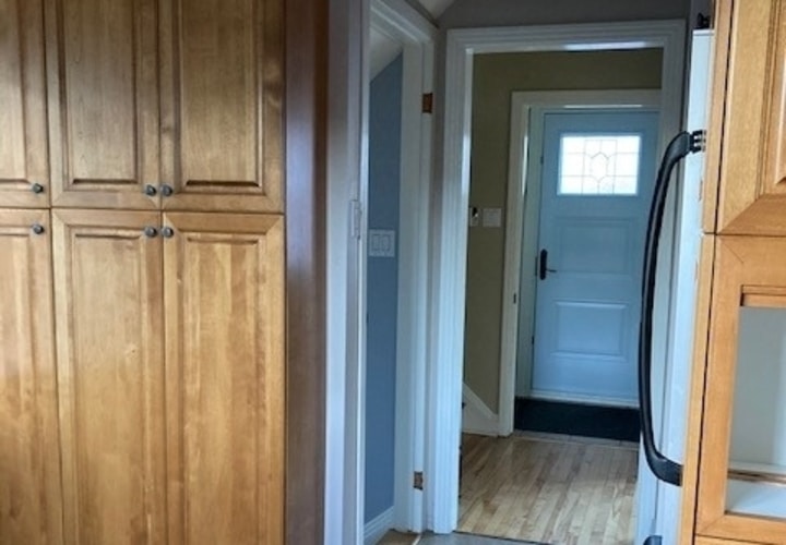 couloir avec armoires de cuisine en bois et murs bleus