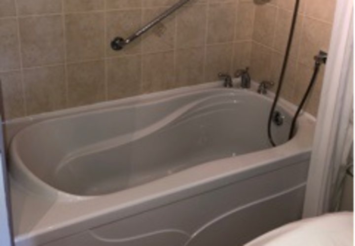 salle de bains avec dosseret beige et baignoire-douche