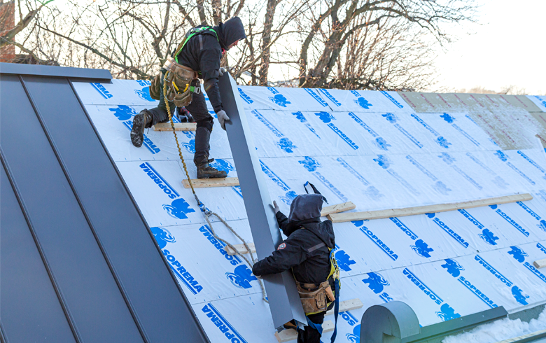 couvreurs installant une toiture en aluminium sur toit en pente