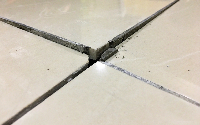 cracked beige bathroom floor tiles