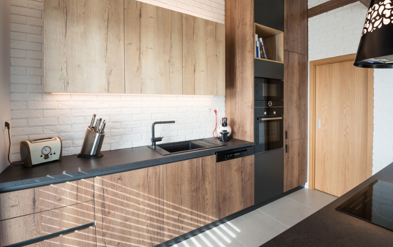 modern kitchen with brown hardwood cabinets and black countertop  