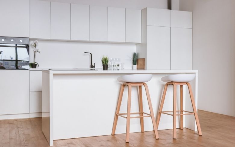 white minimalist kitchen with mdf cabinets and waterfall kitchen island