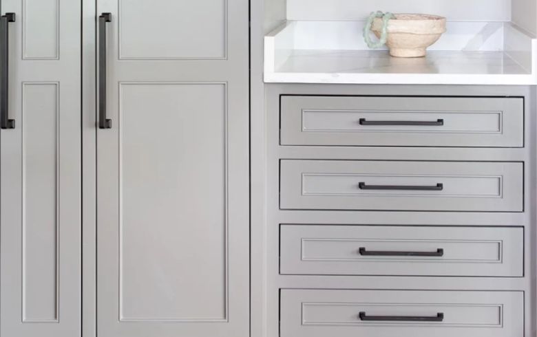 cabinets painted in grey with black matte handles and marble countertop
