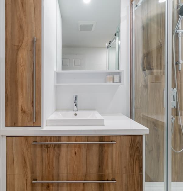 vanité moderne en bois dans une petite salle de bain rénovée