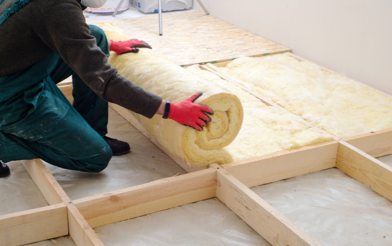 worker installing insulation material for house