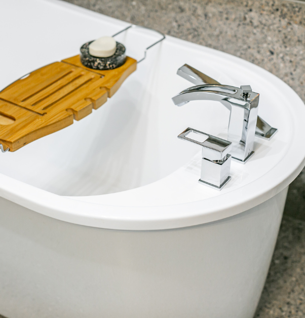 Small oval standalone bathtub with wooden tray