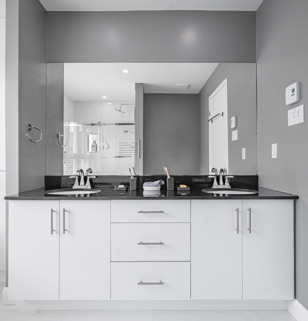 White and black vanity with double sink and large rectangular mirror