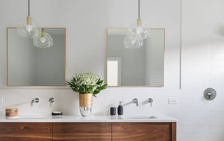 Double wooden vanity with rectangular mirrors and gold pendant lights