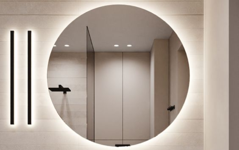 Miroir rond au-dessus d'un meuble-lavabo, éclairé par des DEL et deux lampes rectangulaires à sa droite