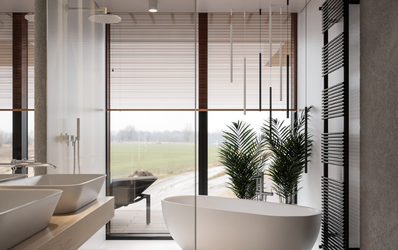 Large bathroom with freestanding tub and floor to ceiling windows with warm lighting