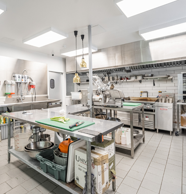 Commercial kitchen with cooking supplies and stainless steel prep tables