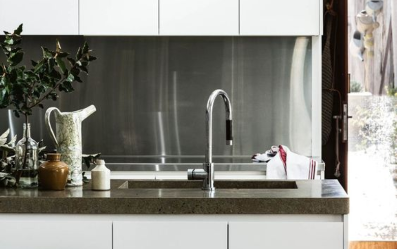 White kitchen with stainless steel backsplash