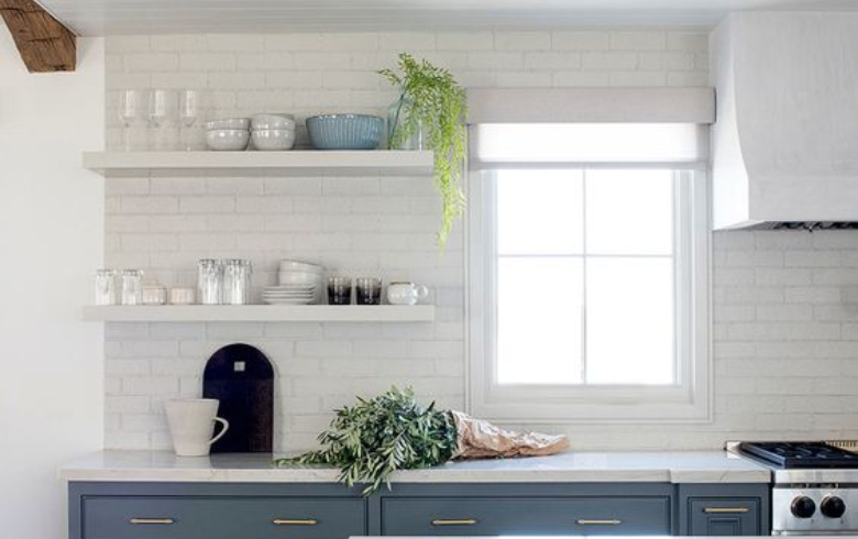 white kitchen with exposed white brick as a backsplash