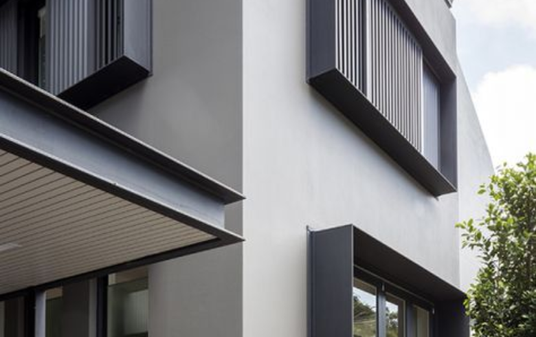 Maison avec revêtement extérieur en acrylique gris et fenêtres noires