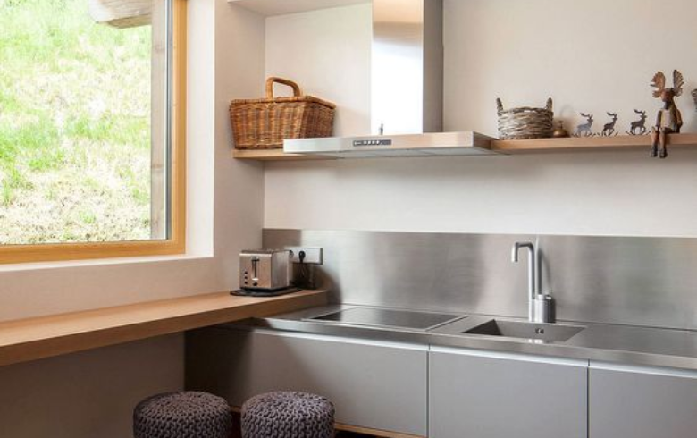 minimaliste kitchen with light grey cabinets ans stainless steel backsplash