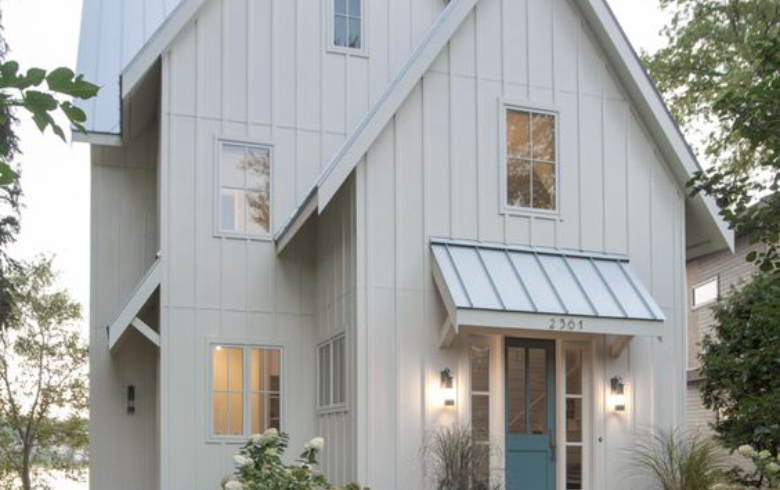 Scandinavian style house with white vinyl exterior and blue door
