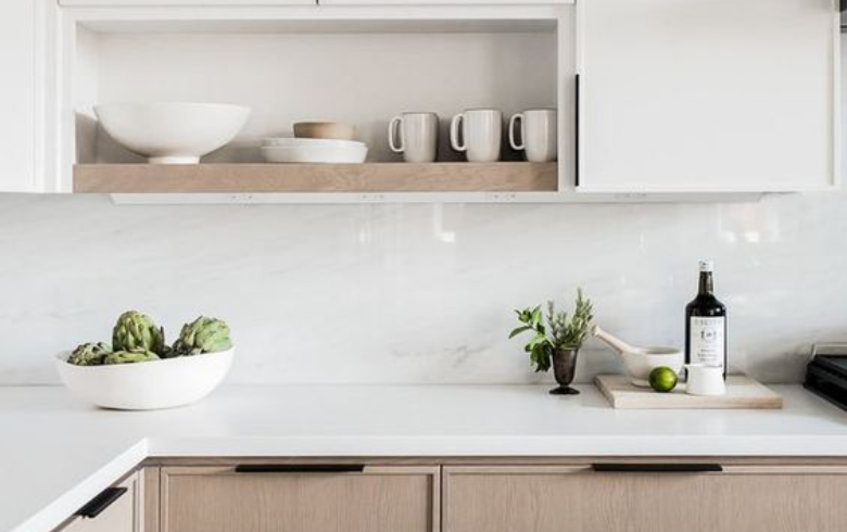 Kitchen with wood and white cabinets and white marble resin backsplash