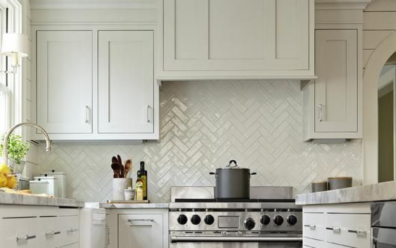 white kitchen with glass herringbone backsplash