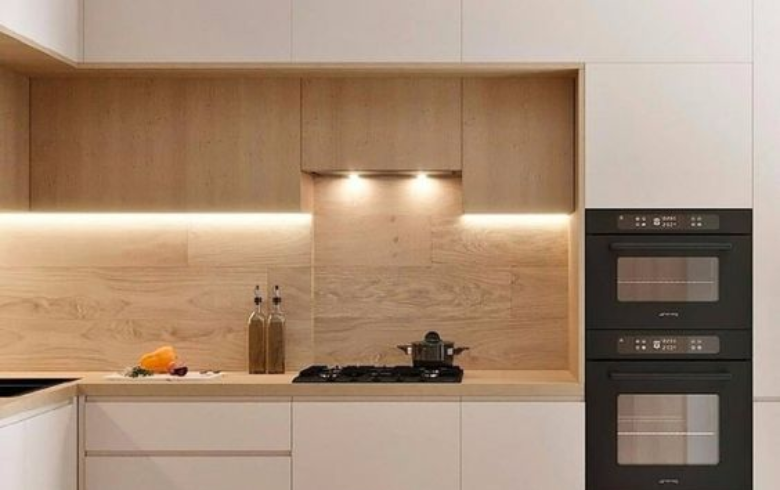 Minimalist kitchen with white cabinets and a white oak backsplash
