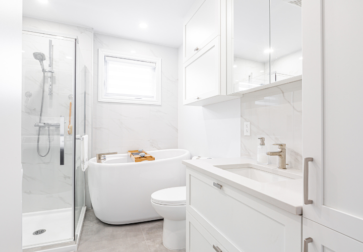 Beautiful renovated white bathroom with walk-in shower, freestanding tub, and white vanity