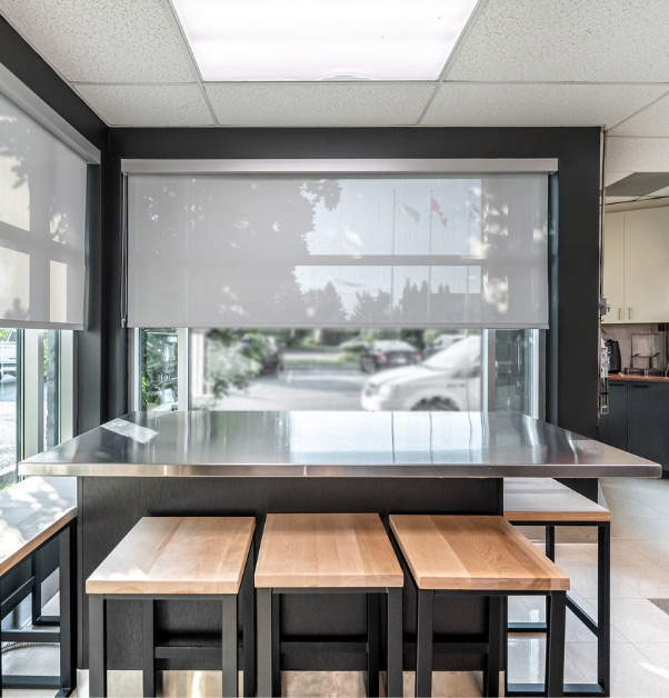 Tasting island with stainless steel countertops and high stools with wooden seats