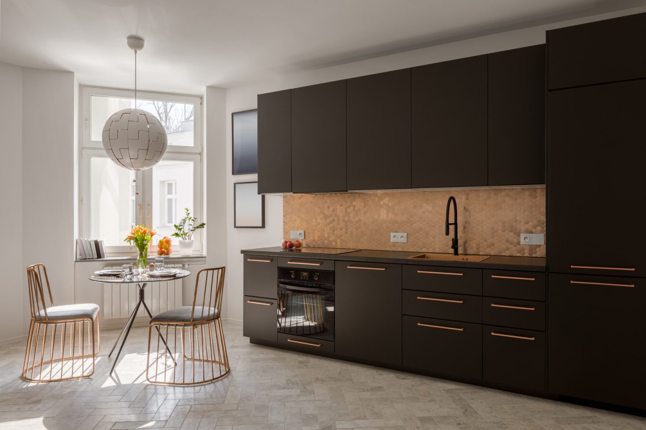 Small kitchen with black cabinets and copper backsplash
