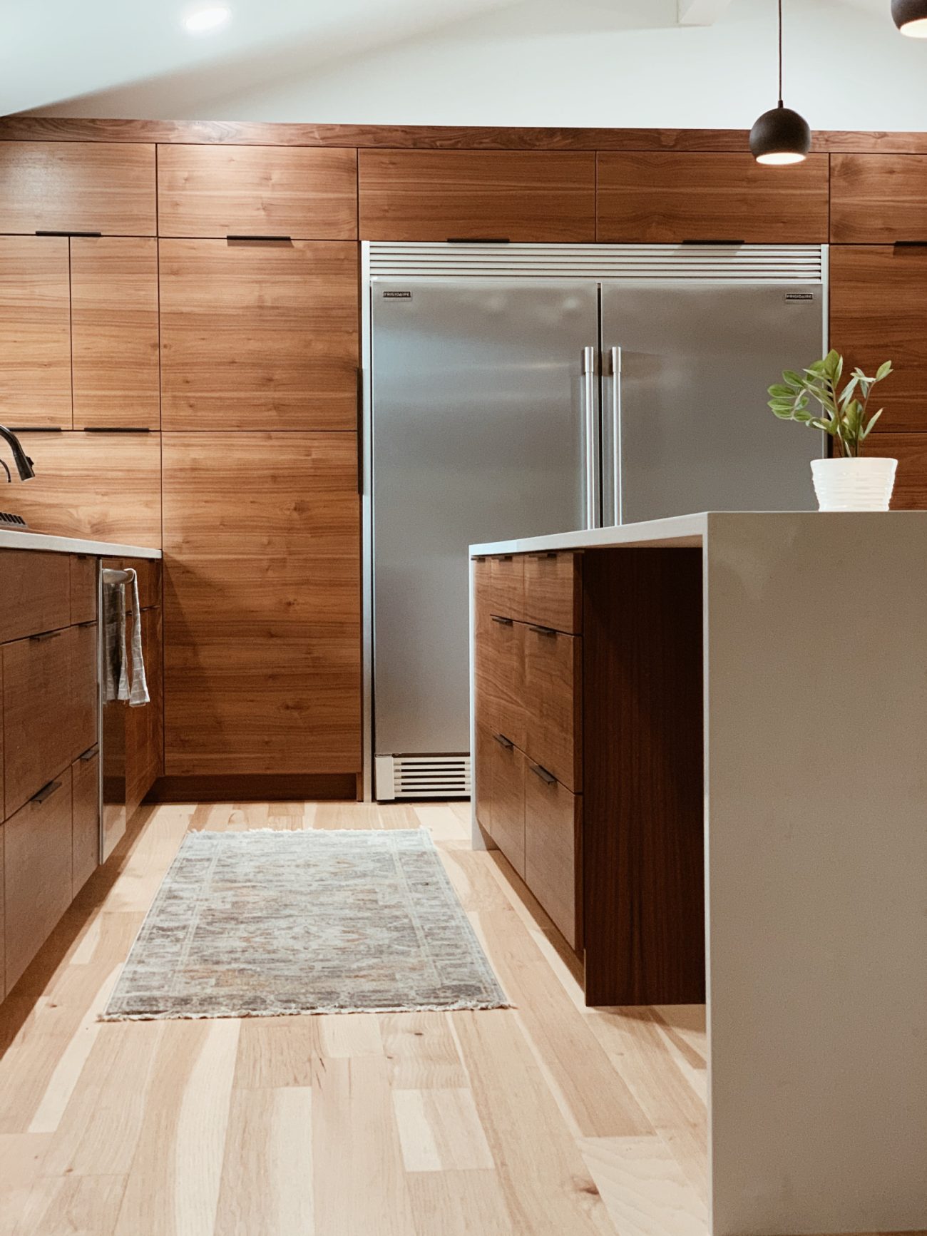 Extra-large refrigerator in a kitchen with wooden cabinets