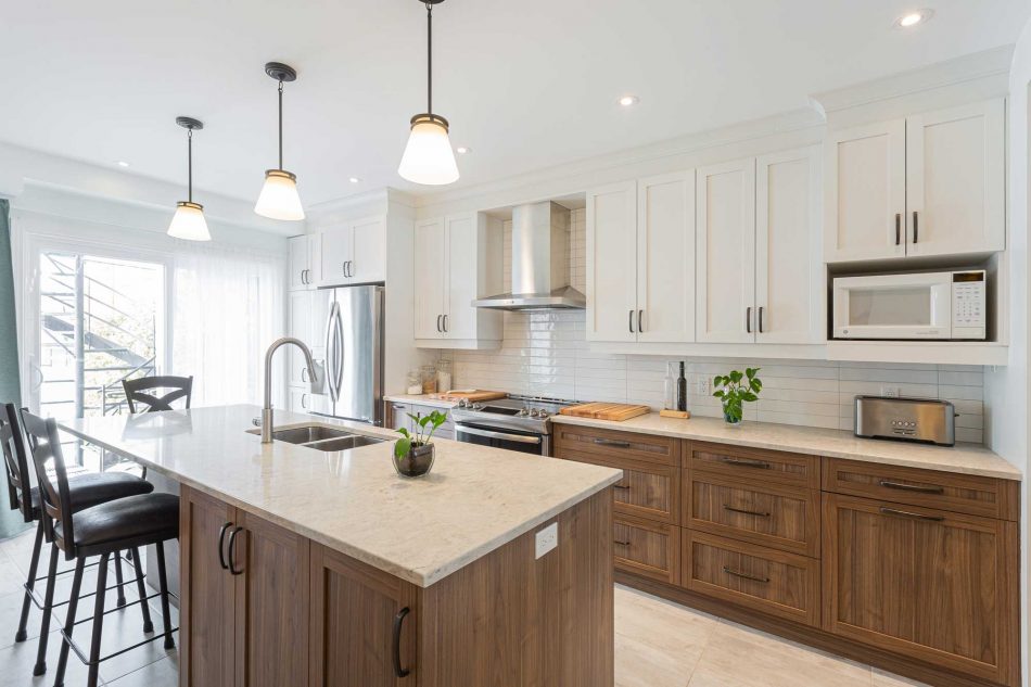 Kitchen with central island including sink and white cabinetry