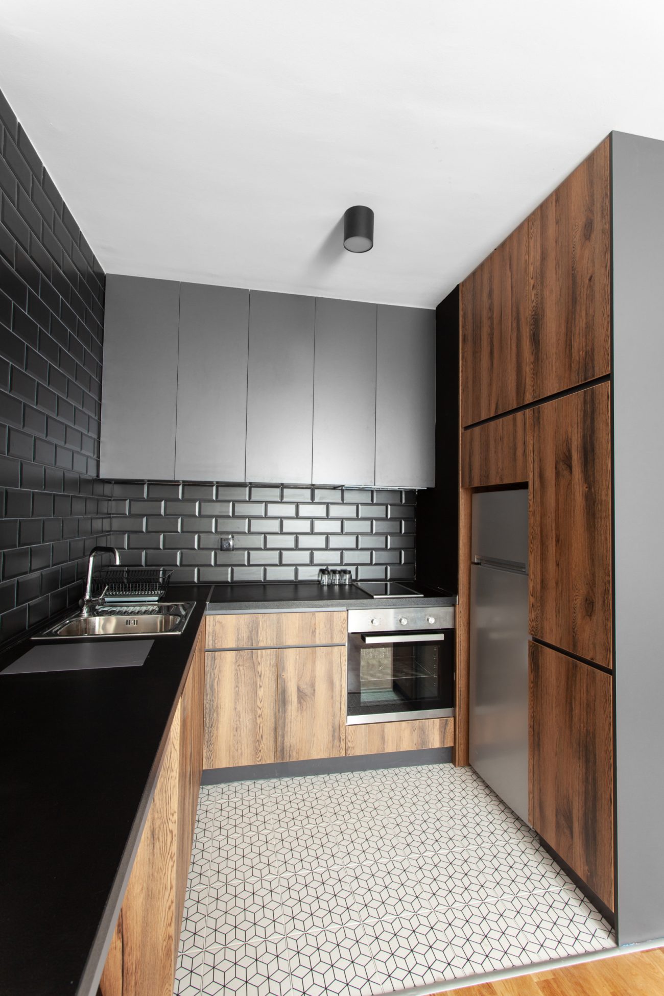 Petite cuisine fonctionnelle comprenant une étagère et des armoires en hauteur, ainsi qu’un grand espace de préparation pour les repas
