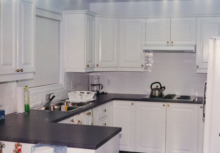 old style kitchen with white cabinets and black counters