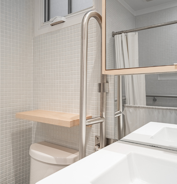 Lavabo et toilette avec rampe de sécurité et miroir incliné dans salle de bain adaptée