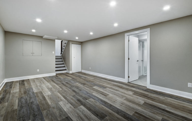 empty and clean basement with grey walls and two-tone floor