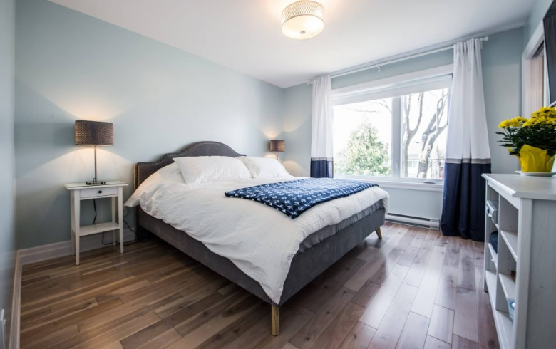 chambre à coucher avec murs bleus et plancher en bois dans extension de maison