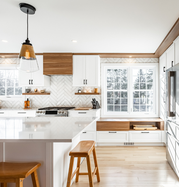 Kitchen renovation with white stone countertops, white cabinetry, and wood accents